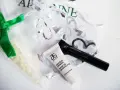 Arbonne opinie: zestaw kosmetyków z primerem i tuszem, w ozdobnym woreczku.