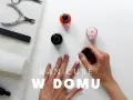 Dłonie malują paznokcie lakierem w domu. Obok buteleczki z różowym lakierem, pilnik, cążki i ręcznik. Klasyczne paznokcie w zasięgu ręki.