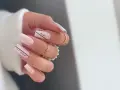 Delikatne, **milky nails** w odcieniach różu, ozdobione czarnymi napisami "smile" i "our moment".