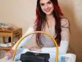 Uśmiechnięta stylistka z rudymi pasemkami przygotowuje się do zabiegu. Dowiedz się, ile kosztuje pedicure w tym salonie.