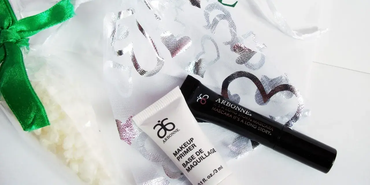 Arbonne opinie: zestaw kosmetyków z primerem i tuszem, w ozdobnym woreczku.