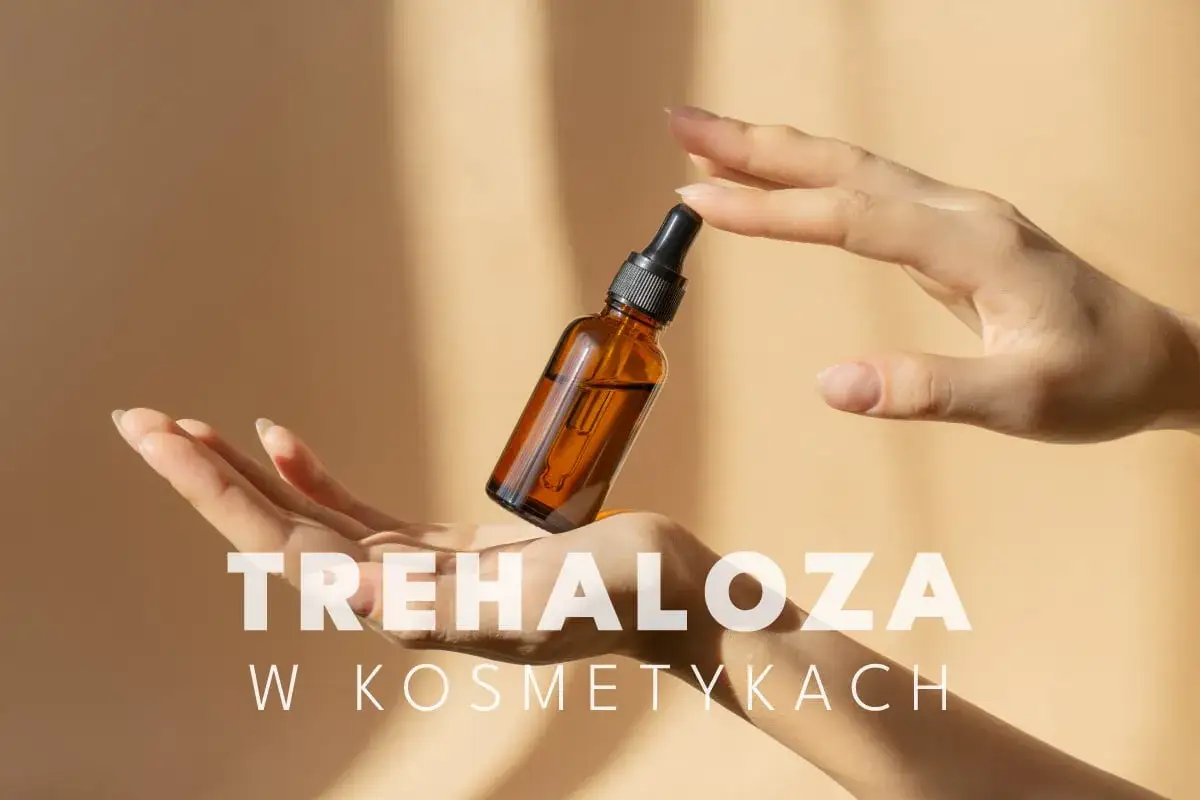 Dłonie trzymają buteleczkę z serum, w którym kluczowy jest składnik trehaloza, znany z właściwości nawilżających i ochronnych.